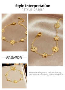 Close-up of gold celestial charm bracelet with sun star and moon on silk fabric