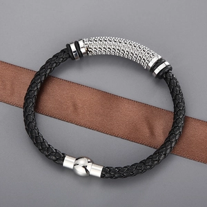 Gros plan d'un bracelet en cuir tressé noir avec fermoir magnétique en acier argent