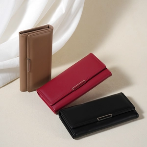 Three elegant long tri-fold wallets in brown, red, and black faux leather with metal clasps