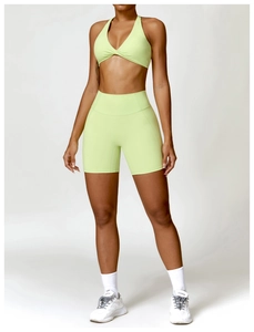 Detail of high-waist seamless compression shorts and lime green cross-neck yoga bra set