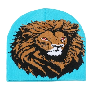 Close-up of bright blue knit beanie featuring a detailed lion face woven pattern