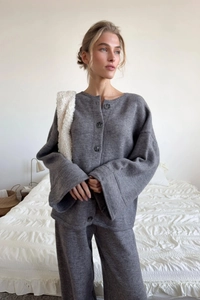 Detail of grey knitted cardigan and wide-leg pants set showing thick premium wool texture