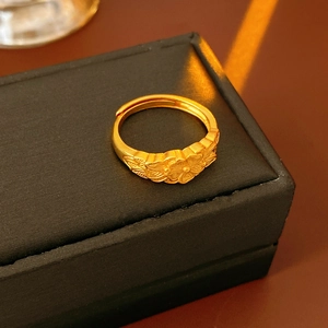 Primo piano dettagliato di un anello a fiore dorato vintage con incisioni floreali fini