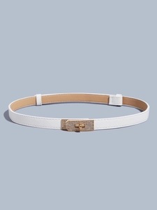 Detail of white slim leather belt with a golden rhinestone lock buckle on blue background