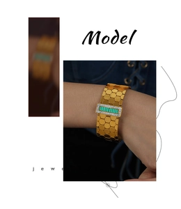 Detail of gold honeycomb cuff bracelet featuring a green malachite inlay and zircon accents