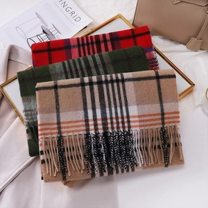 Detailed view of folded wool scarves with classic plaid patterns and tassel fringe details