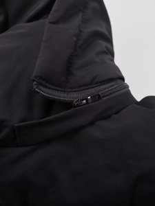 Detailaufnahme des Metallreißverschlusses an einer schwarzen Steppjacke aus winddichtem Stoff