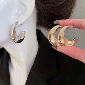 Polished chunky C-shaped hoop earrings in gold and silver finish for a modern look