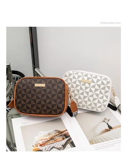 Detail of two stylish crossbody square bags with geometric patterns and wide woven straps