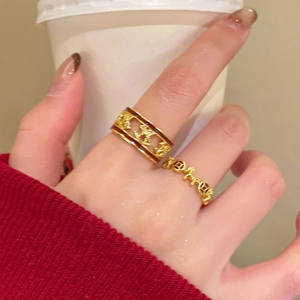 Detailed view of hollow horse rings with red enamel edges worn on a finger