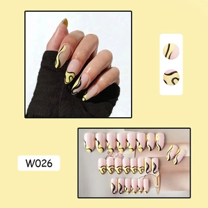 Close-up of almond shaped press-on nails with yellow French swirls and pink base