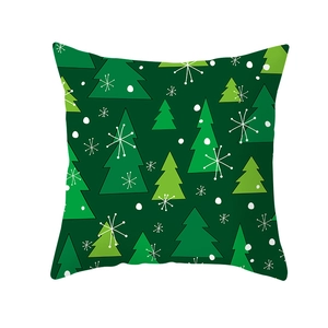 Detail of dark green Christmas pillow cover featuring festive pine tree patterns and snowflakes