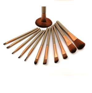 Detail of 10-piece makeup brush set with golden handles and brown synthetic bristles