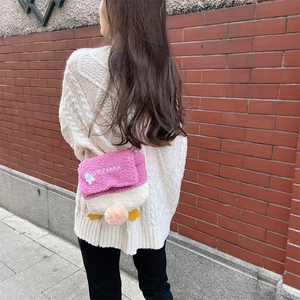 Detail of plush lamb wool duck crossbody bag with pink flap and cute bunny patch
