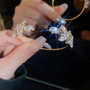 Close-up of golden leaf bangle featuring marquise-cut sparkling cubic zirconia crystals