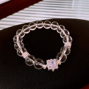 Macro view of crystal beaded bracelet with square zircon charm and silver floral spacers