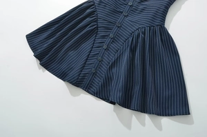 Détail de la robe à rayures bleu marine montrant les motifs verticaux et les boutons