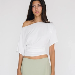 Détail du t-shirt blanc à épaule dénudée avec un design froncé à la taille ajustée