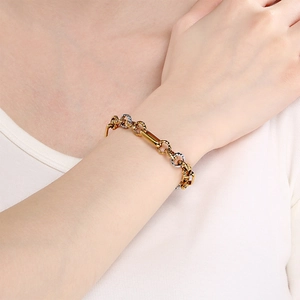 Detail of two-tone gold and silver titanium steel chain worn on a model's wrist