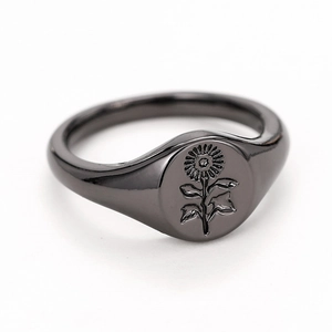 Detail of vintage black sunflower seal ring featuring intricate floral engraving