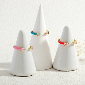 Detailed view of three gold adjustable enamel rings with pear-cut cubic zirconia crystals