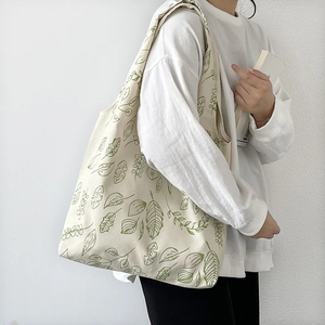 Detail of canvas tote bag with green leaf print showing large capacity and thick texture