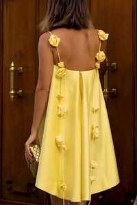 Detail of yellow satin dress featuring floral strap design and elegant open back style