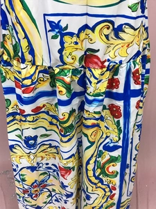 Detail of Maiolica print dress showing vibrant floral tile patterns and satin fabric