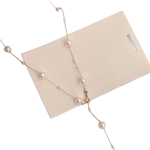 French vintage pearl necklace with golden metal chain and pink pearls on a display card