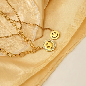 Collier chic multicouche doré à visage souriant avec zircons sur tissu en soie