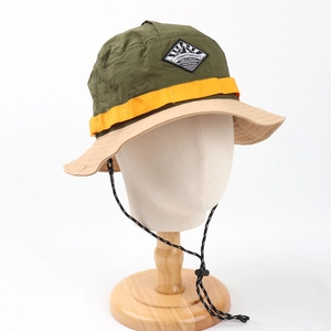 Detail of color-block sun hat featuring adjustable windproof cord and diamond logo patch
