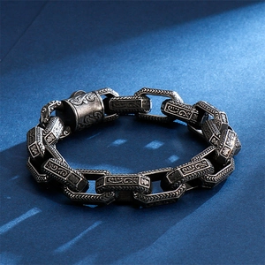 Macro view of vintage titanium steel chain links with intricate floral engravings