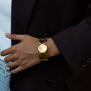 Detail of 18K gold stainless steel hammered circular bangle on a model wrist