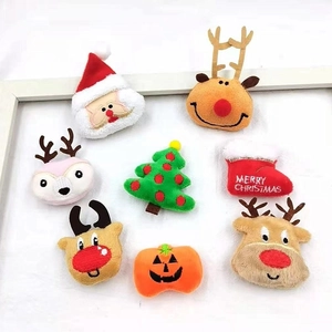 Flat lay of plush Christmas brooches featuring Santa, reindeer and tree accessories