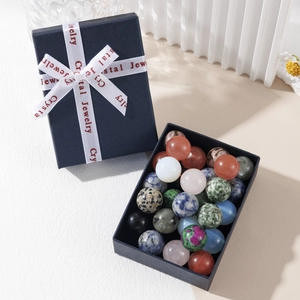Polished natural crystal sphere set inside a blue gift box with a white ribbon