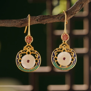Detail of Chinese retro earrings with red Fu character and faux jade on a branch