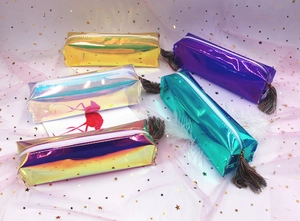 Close-up of colorful laser holographic pencil cases with decorative tassels and zipper
