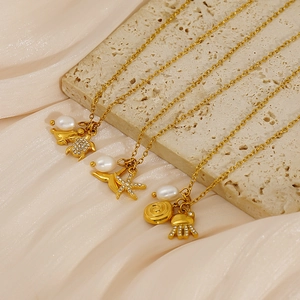 Elegant gold ocean life necklaces with sea turtle, starfish and pearl on stone base