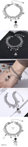 Macro detail of silver layered bracelet with astronaut pendant and triple chain design