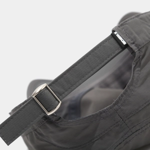 Detail of dark grey quick-dry fabric texture and adjustable metal buckle on military cap