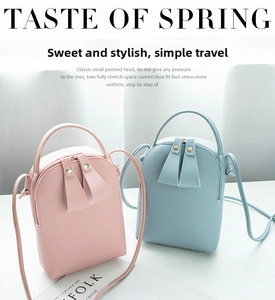 Detail of mini semi-circle PU leather crossbody bags in soft pink and sky blue colors