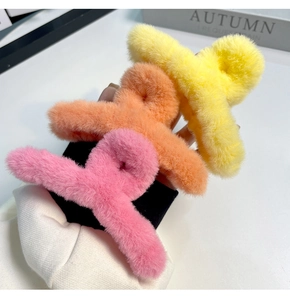 Gros plan de trois pinces à cheveux en peluche de 14 cm en jaune, orange et rose doux