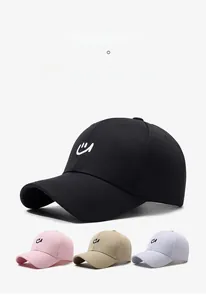 Detail of minimalist baseball caps in four colors featuring a small white smile embroidery