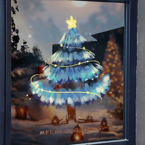 Blue Christmas tree window sticker with yellow star on a blurred snowy night background