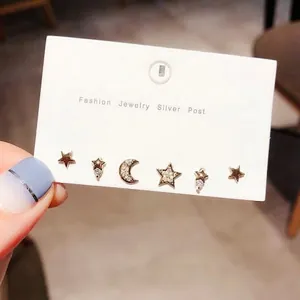 Detailed view of six gold star and crescent moon stud earrings with zircon inlays