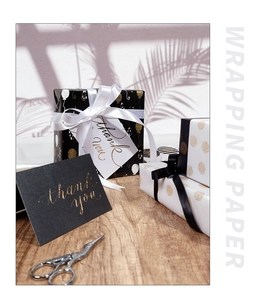 Detail of gold balloon and dot wrapping paper with satin ribbons and thank you tags