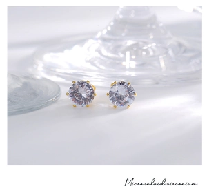 Vue macro de boucles d'oreilles couronne plaquées or 18K avec zircons cubiques incrustés