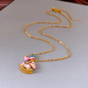 Golden carousel horse pendant necklace with colorful enamel details and pink heart charm