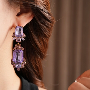 Close-up of vintage geometric square earrings featuring purple stones and metal inlay