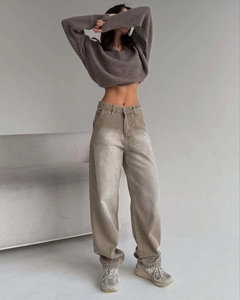 Détail du jean marron vintage à taille haute avec un pull en maille de qualité supérieure
